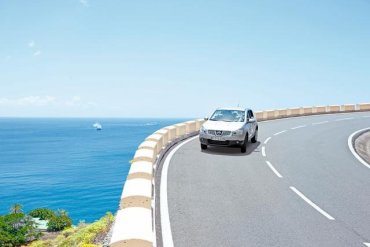 auto idúce po ceste pri morskom pobreží