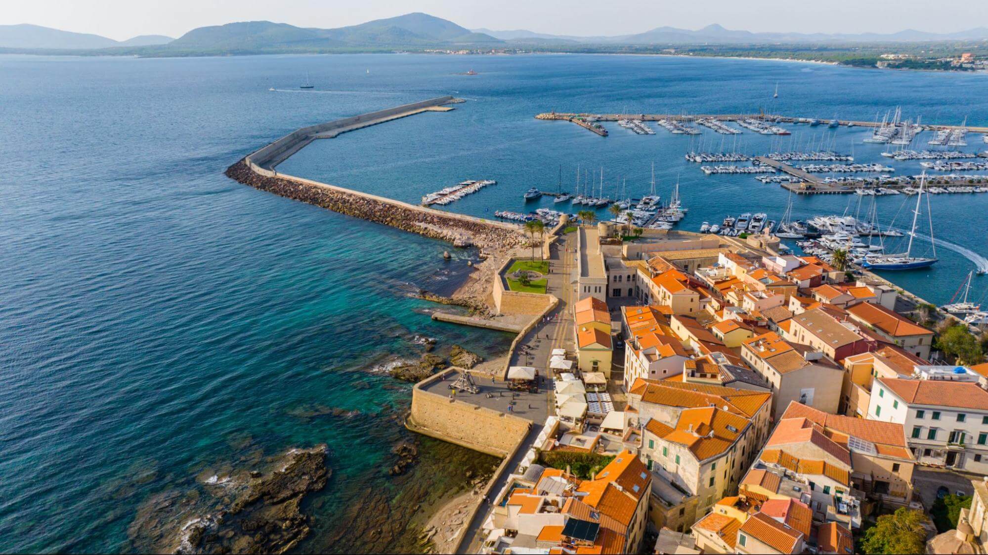 Hradby centra Alghera s vežou Torre di Sant’Elmo a prístavom Porto di Alghero.